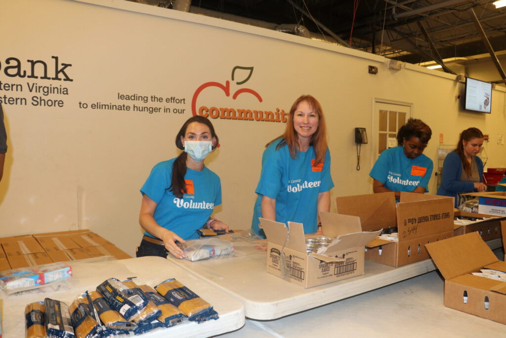 Two PRA employees work together preparing Foodbank packages.