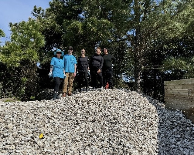 A group of five volunteers smiling at the top of a hill.